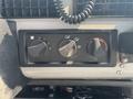 Dashboard controls of a 1999 Freightliner FL80 featuring three dials for fan speed and temperature adjustment
