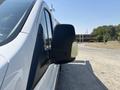 A 2019 Ford Transit 350 side mirror reflecting light with a close-up view of the vehicle's profile