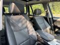 Interior of a 2013 BMW X3 featuring black leather seats with adjustable headrests and a center armrest