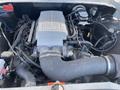 Engine compartment of a 1962 Ford 2WHDR featuring a gray engine cover with Ford Mustang logo and various engine components including wires and hoses