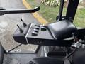 A control panel with two joystick levers and four buttons on a black surface inside the cabin of a 2019 Madvac LS175 machine