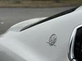 Close-up of the Maserati logo on a 2016 Maserati Ghibli featuring a trident design and sleek detailing in silver metallic finish