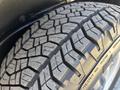 A close-up of a tire from a 2011 Chevrolet Colorado featuring a rugged tread pattern designed for traction and durability