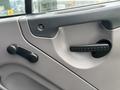 The interior door panel of a 2013 Freightliner 114SD with a door handle and window crank visible