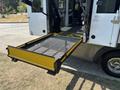 A wheelchair lift extended from the back of a 2020 Chevrolet Express, featuring a mesh surface and a yellow border
