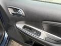 Inside a 2013 Dodge Journey showing the driver's side door panel with controls for windows and door locks