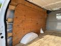 Inside a 2013 Ford Econoline cargo van featuring a wooden panel lining the walls and a wooden floor with some white plastic components visible