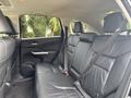 Interior view of a 2014 Honda CR-V showing the back seat with black leather upholstery and seat belts attached