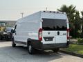 A 2017 RAM Promaster van with a white exterior and black rear accents parked with the rear visible