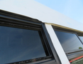 Close-up of the roof seam and windows of a 2020 Chevrolet Express showing black trim and clear glass
