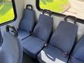 Interior of a 2014 Chevrolet Express featuring blue fabric seats with seatbelts and a simple design