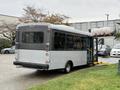 A 2020 Chevrolet Express with a wheelchair lift extended from the side door parked at an angle suggestive of a transportation or shuttle service