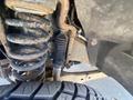 Close-up of a 2016 Ford F-350 SD showing the undercarriage with a suspension coil spring and a visible tire tread pattern
