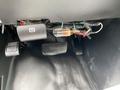 Interior view of a 2020 Chevrolet Express showing the gas and brake pedals along with various wires and a small component mounted near the pedals