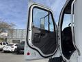 A 2016 Freightliner 108SD truck door is open displaying the interior view and dashboard with a side mirror and window visible