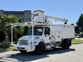A 2010 Freightliner M2 106 bucket truck with a white body and a raised hydraulic lift on top for accessing high places