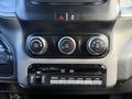 The dashboard controls of a 2021 RAM 5500 featuring climate control knobs and multiple switches for auxiliary functions