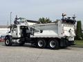 A white 2013 International WorkStar dump truck with a large bed and distinctive front cab design parked with visible tools and attachments on the chassis