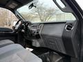 Interior of a 2012 Ford F-550 featuring a gray dashboard with controls and an audio system seating area in gray upholstery