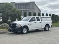A 2016 RAM 1500 truck in white with a black grille and four doors parked in a residential area