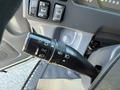 A close-up view of the multifunction turn signal lever inside a 2012 Isuzu NPR HD with controls for headlights wipers and cruise settings