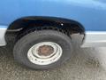 A blue 2009 Ford Econoline with a visible tire and wheel in the foreground