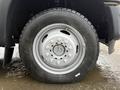 A close-up of a 2015 Ford F-450 tire showing a silver steel wheel and a rugged tire tread design