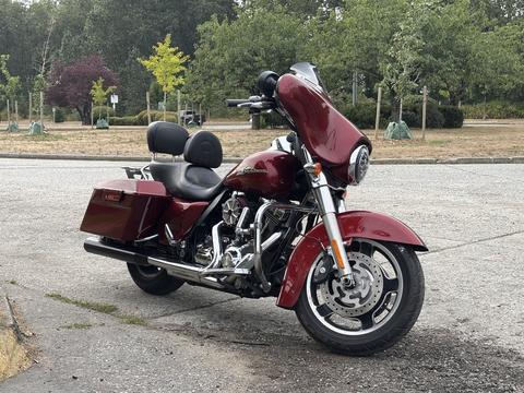 A 2009 Harley-Davidson Road King motorcycle in a deep red color with a comfortable passenger seat and a large front fairing