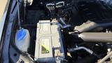 A 2016 Ford F-150 engine compartment displaying the battery and various engine components