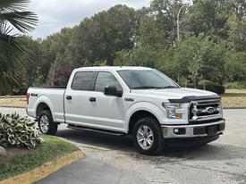 A white 2017 Ford F-150 pickup truck with a crew cab and off-road tires parked on a paved surface