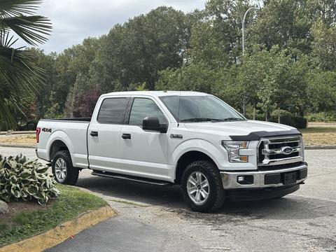 A white 2017 Ford F-150 pickup truck with a crew cab and off-road tires parked on a paved surface