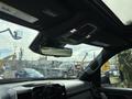 Interior view of a 2021 RAM 1500 showing the rearview mirror and overhead controls with a digital display on the dashboard