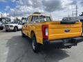 A yellow 2017 Ford F-250 Super Duty truck with a bed rack visible from the rear angle showcasing its robust design and large tires