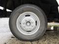 Close-up view of a silver wheel and tire from a 2012 Ford Econoline showing the tread and lug nut design