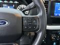 Close-up of the steering wheel of a 2023 Ford F-250 showing buttons for menu navigation and audio controls