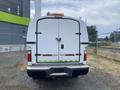 A white 2014 Ford F-350 SD with a storage compartment in the rear and reflective markings on the bumper
