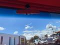 Interior view of a 1962 Ford 2WHDR showing the rearview mirror mounted on the windshield reflecting the sky