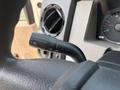 Close-up of a 2009 Ford F-450 Super Duty turn signal lever positioned on the steering column with various function markings
