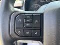A close-up of the steering wheel controls of a 2021 Ford F-150 featuring buttons for cruise control audio and settings