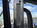 A metal identification plate mounted inside a Kenworth T370 truck displaying details such as truck model engine model and caution notes about warranty and weight