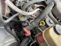 Close-up of the engine components in a 2012 International TerraStar showing various hoses caps and wires with a focus on the oil filler cap and nearby coolant reservoir