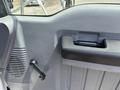 Interior door panel of a 2015 Ford F-750 featuring a handle and a window crank mechanism