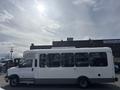 A 2018 Chevrolet Express with a white exterior and large side windows designed for passenger transport