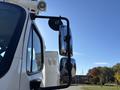Close-up of the side mirror and window of a 2005 Freightliner M2 106 truck showing chrome details and a reflective surface