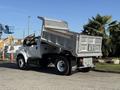 A 2017 Ford F-650 Super Duty truck with a raised dump bed revealing its cargo area