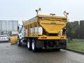 A 2016 International 7400 truck with a yellow dump body and multiple compartments for transporting materials