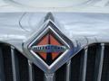 Close-up of the chrome grille and emblem of a 2014 International Durastar featuring an orange and black design with the word International centered
