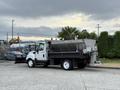 A 2012 International TerraStar truck with a plow attached in the front and a large salt spreader mounted in the rear