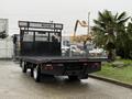 A 2015 Hino 195 flatbed truck showing a black platform and a rear guard with a lattice design