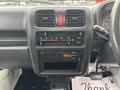 Interior view of a 2010 Suzuki Carry dashboard featuring controls for climate, audio system, and display screen showing time and radio settings